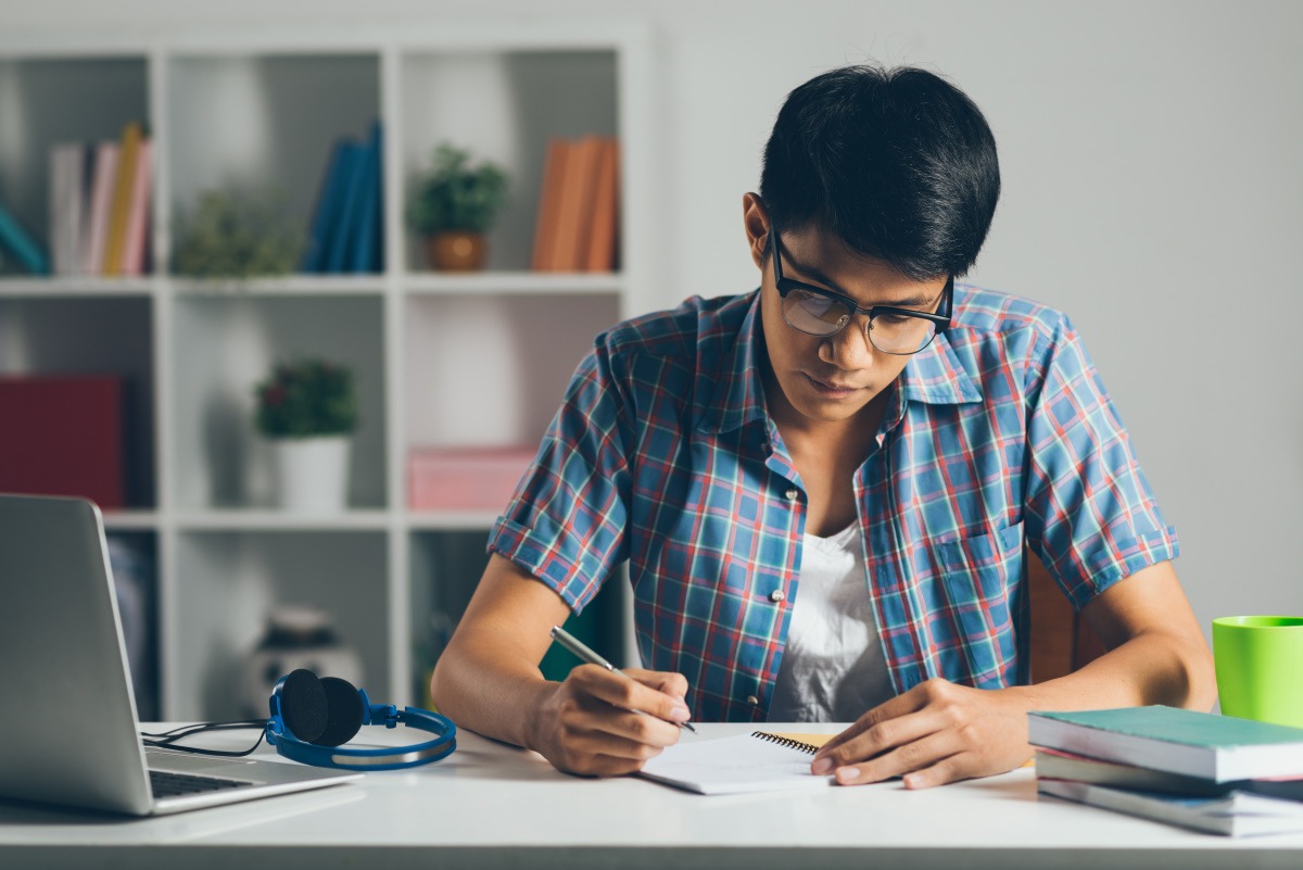 student working on schoolwork in his apartment