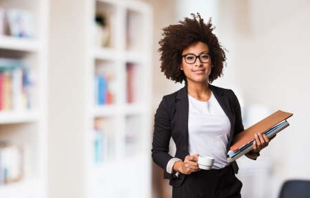 young female professional holding paperwork and wearing business attire