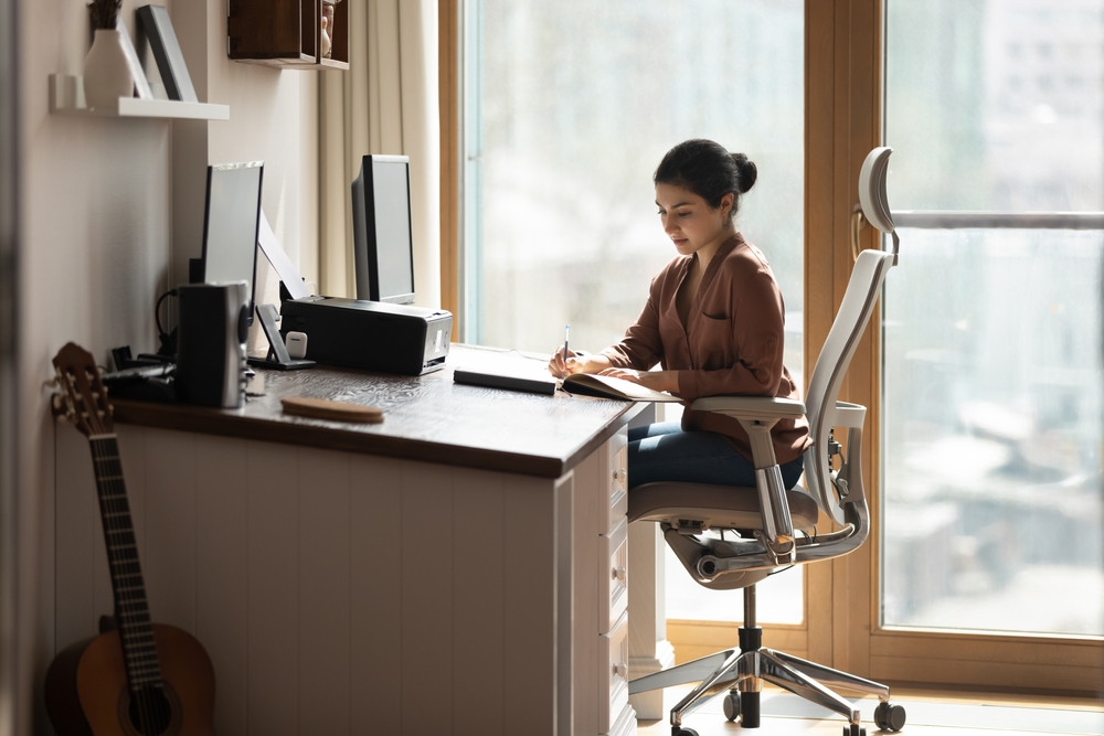 woman working from home with an ergonomic chair to support her back