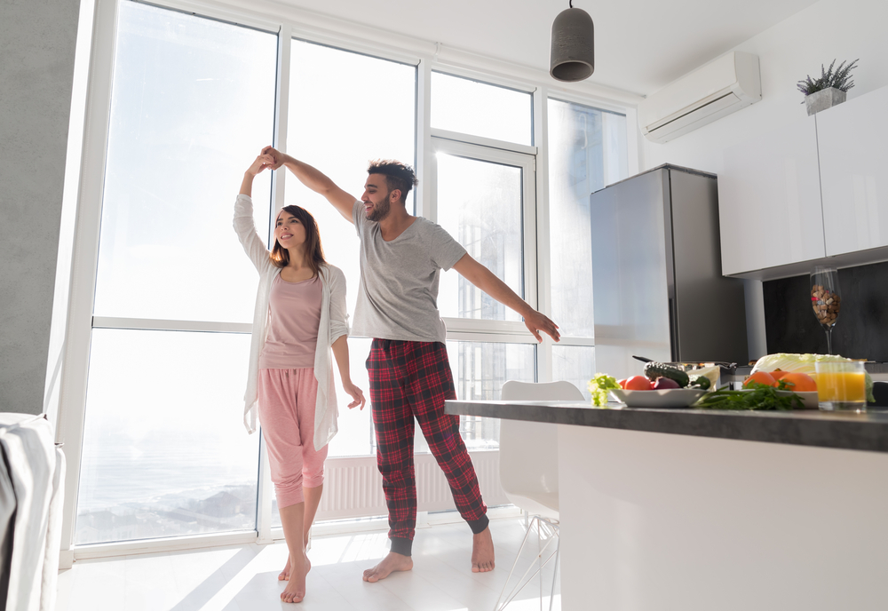 young couple dances in apartment kitchen