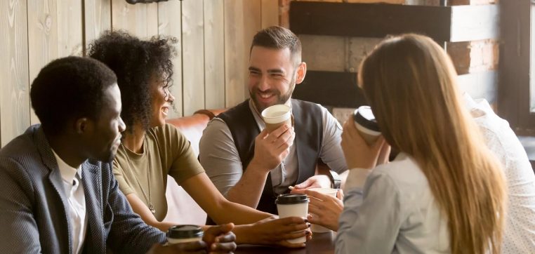 Smiling-friends-enjoying-time-together-having-coffee-in-cafe-991406836_5472x3648